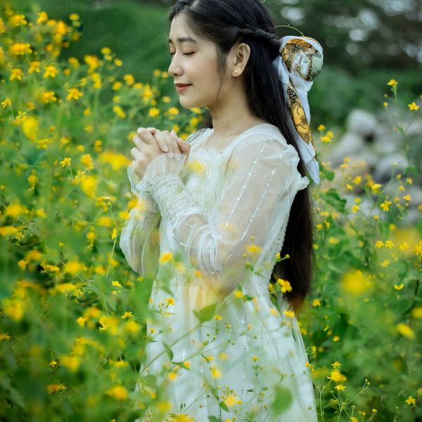 Person meditating peacefully outdoors, surrounded by nature.